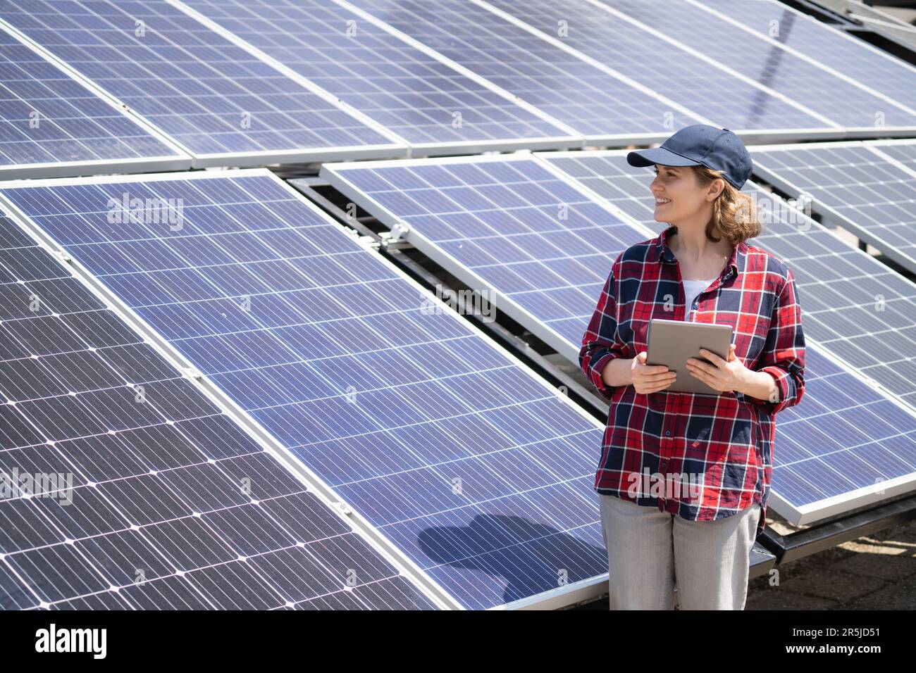 Woman with digital tablet on a background of mobile solar power station. Stock Photo