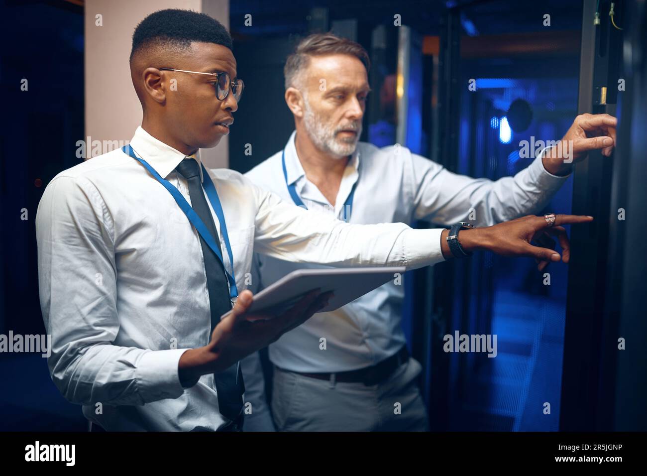 The solution is what theyre working on. two technicians using a digital tablet while working in a server room. Stock Photo