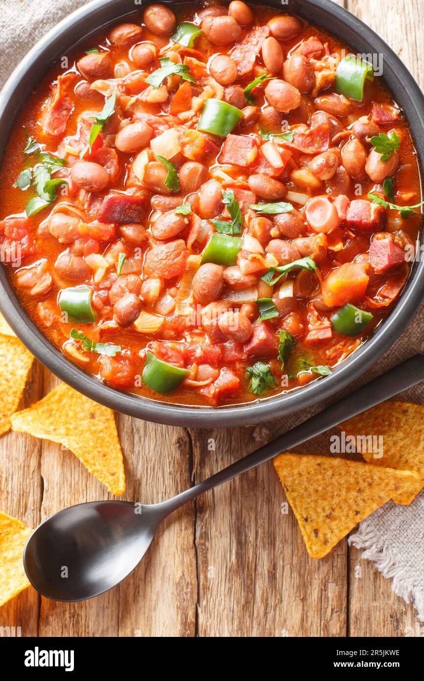 Mexican Charro Beans or Frijoles charros is made with pinto beans, tomatoes, sausages, bacon and onions simmered in the most flavorful broth closeup o Stock Photo