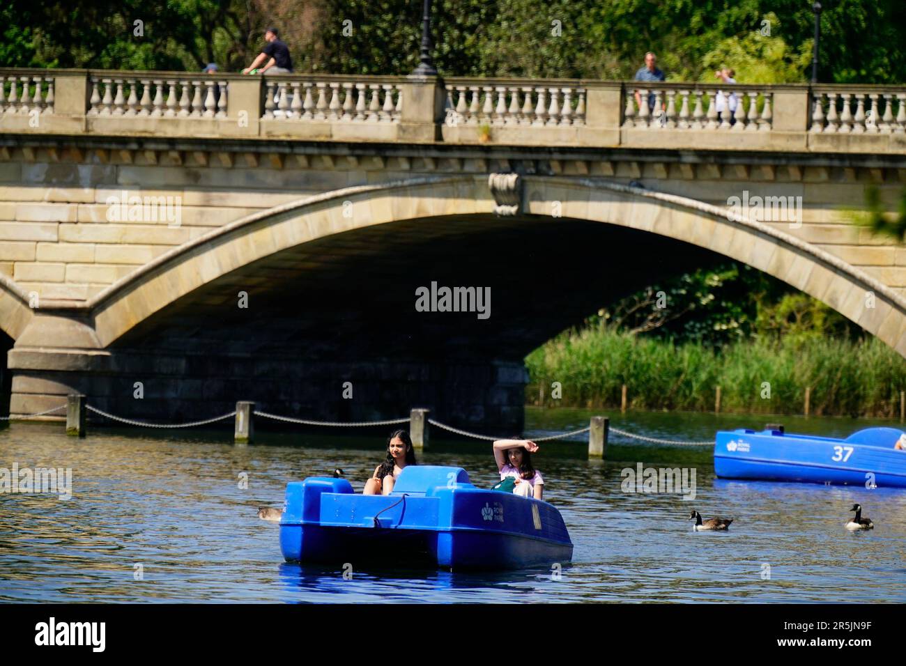 People ride pedalo and rowing boats in the hot weather on the