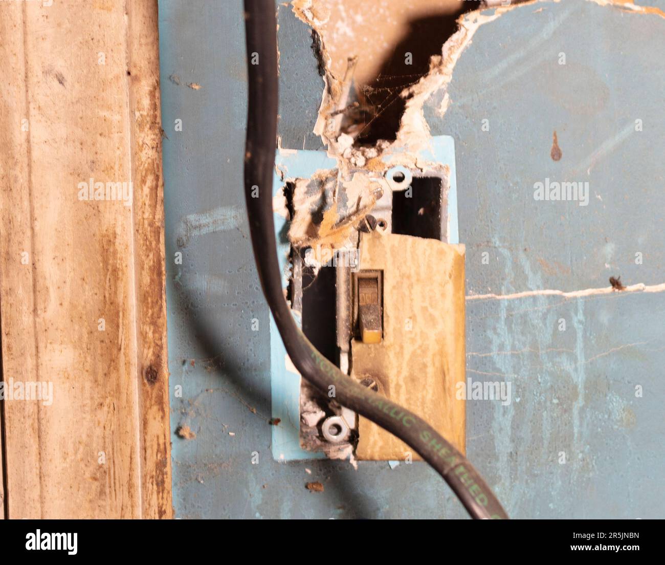 Wire hanging from a wall switch after criminals were stopped from