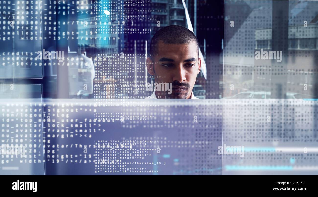 Closing in on the code. a young computer programmer looking through data. Stock Photo