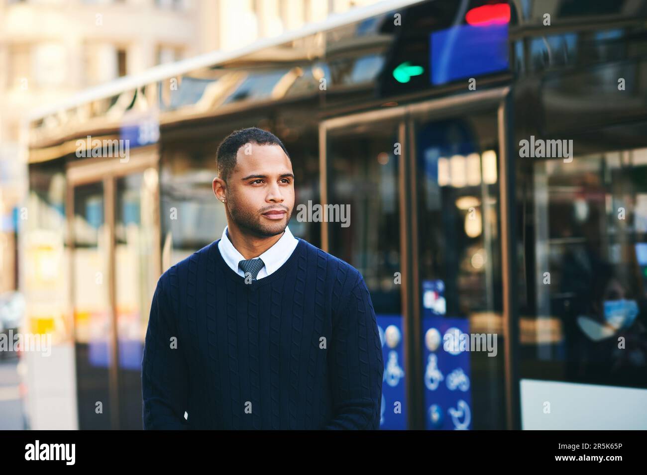 Urban portrait of handsoma African American man, posing outside wearing blue pullover Stock Photo