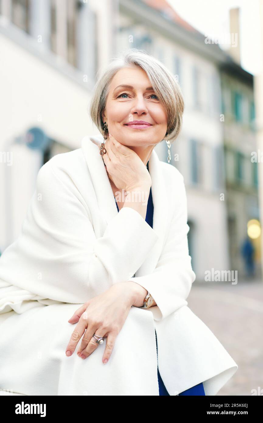 Outdoor portrait of beautiful and elegant middle age 55 - 60 year old