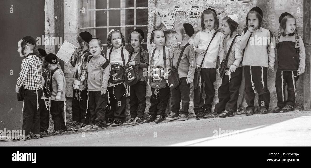 Young Ultra-Orthodox Jewish kindergarten (CHEDER) boys standing, waiting for the transportation to take them back home after the end of the day. Stock Photo