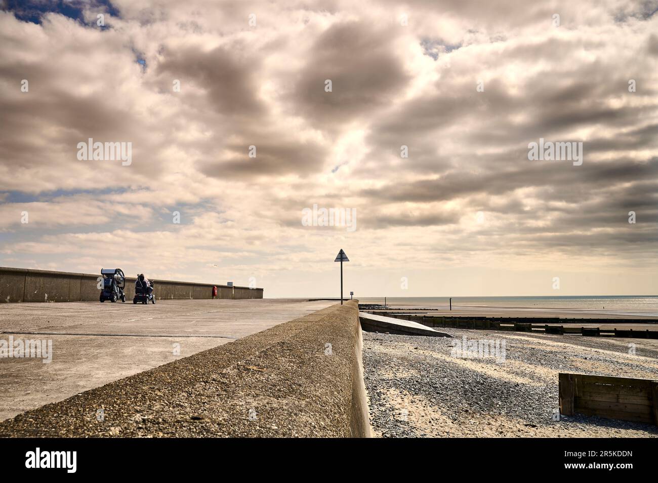 Two mobility scooters driving seawall  at Fleetwood,UK Stock Photo