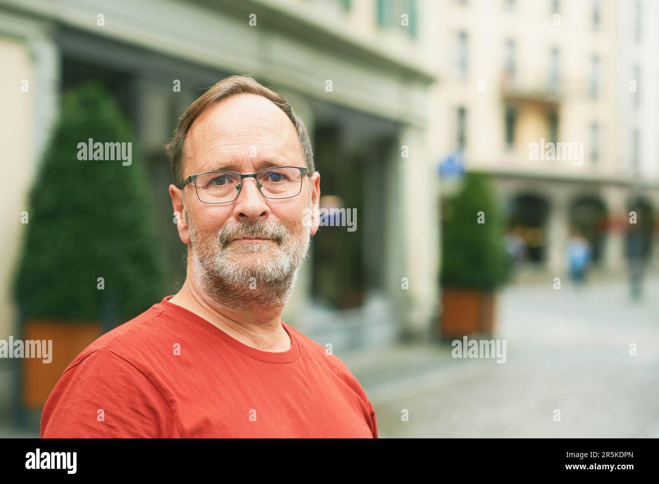 Outdoor portrait of middle age man on city street, wearing eyeglasses Stock Photo