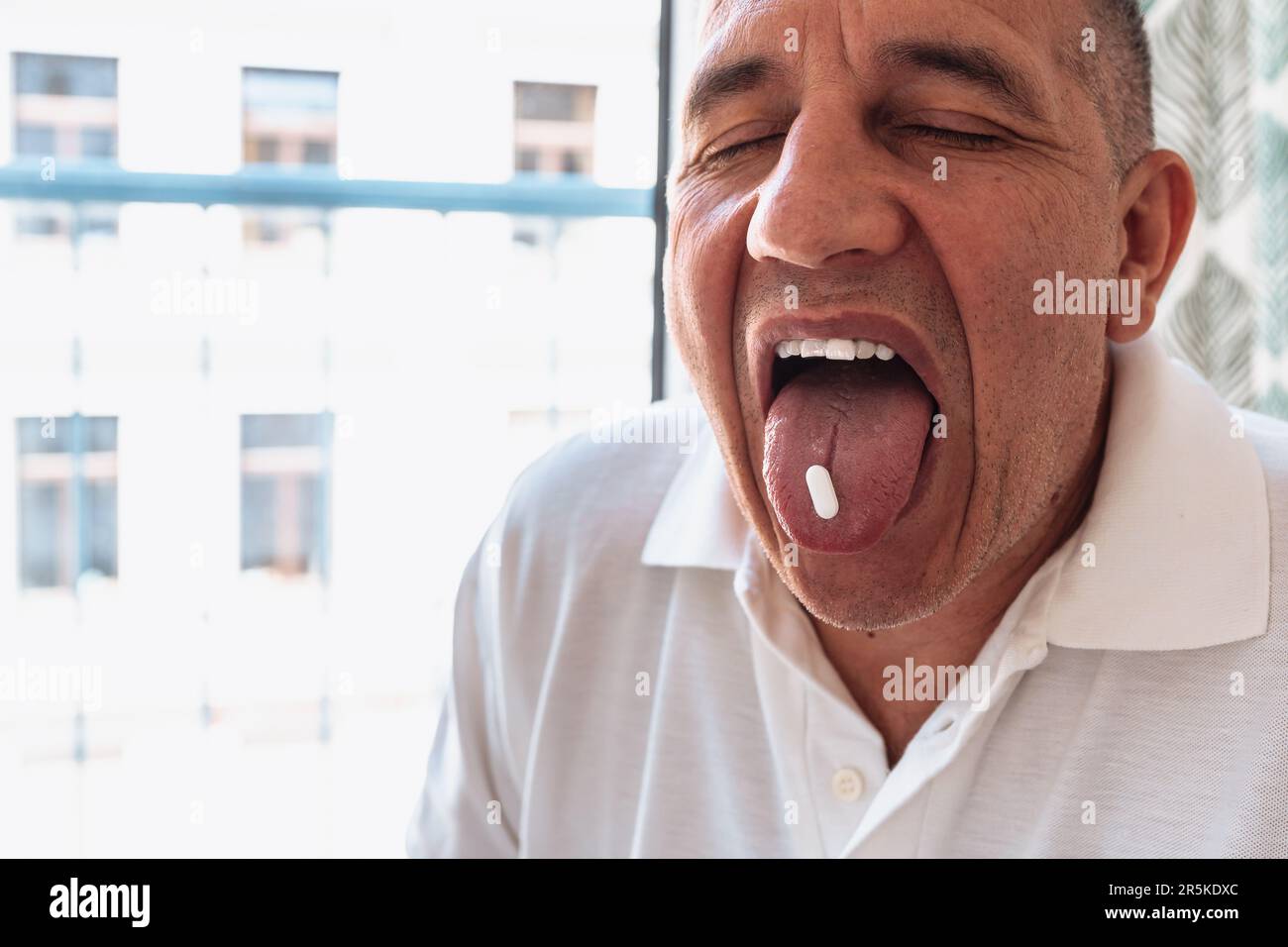 Closeup middleaged man with his eyes closed, mouth open, tongue