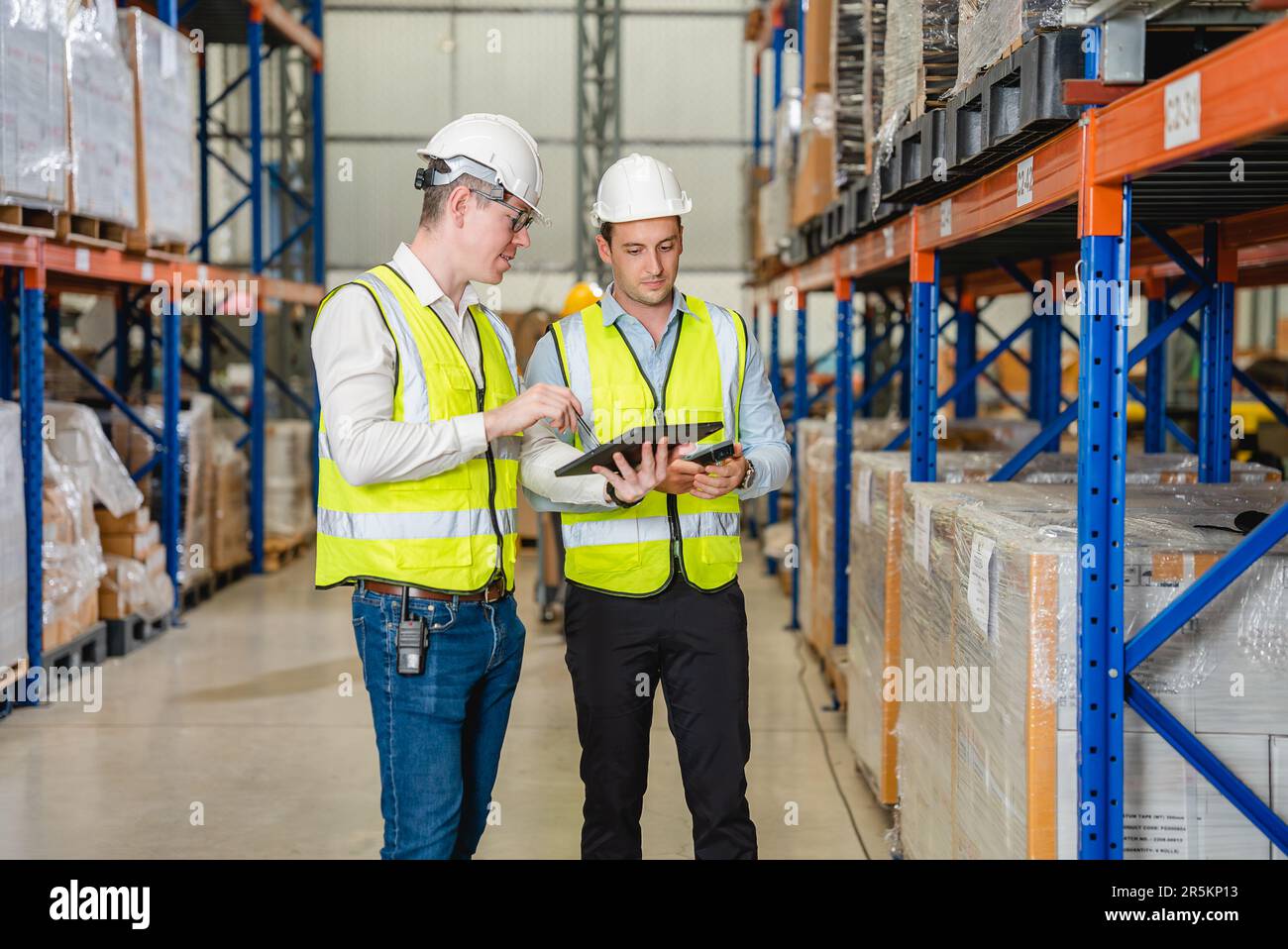 Warehouse workers talking together checking goods in storage Stock Photo