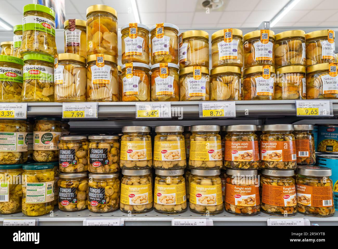 Italy -May 31, 2023: Mushrooms in oil preserved in glass jars on shelves in Italian supermarket. cep and  meadow mushrooms canned Stock Photo