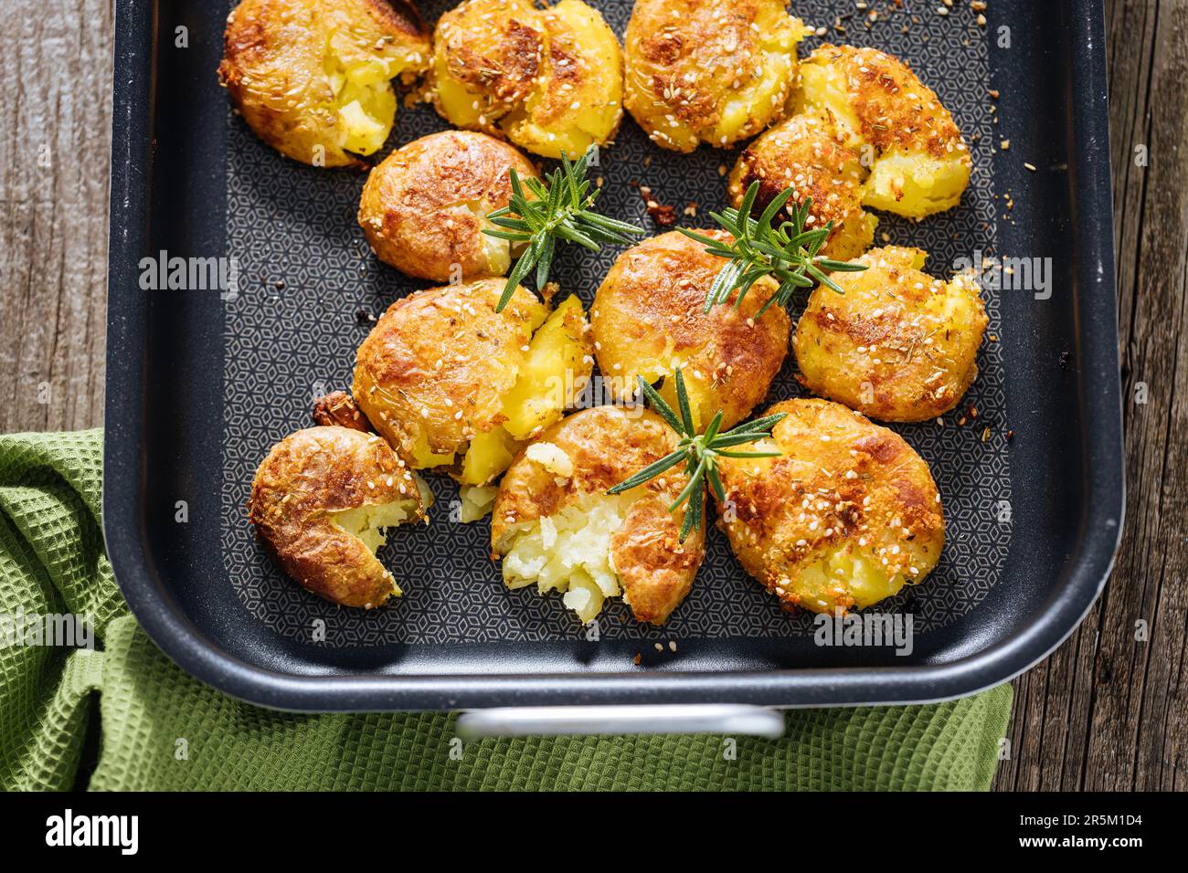 Baked or roast potatoes in metal tray seasoned with rosemary and salt