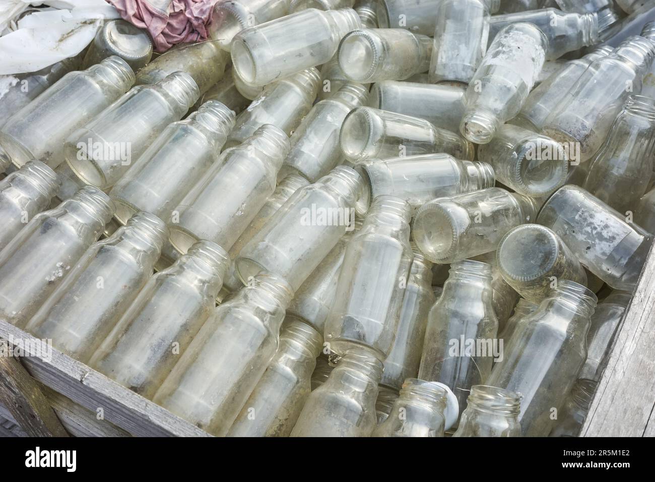 Used empty glass bottles stored for recycling, selective focus Stock