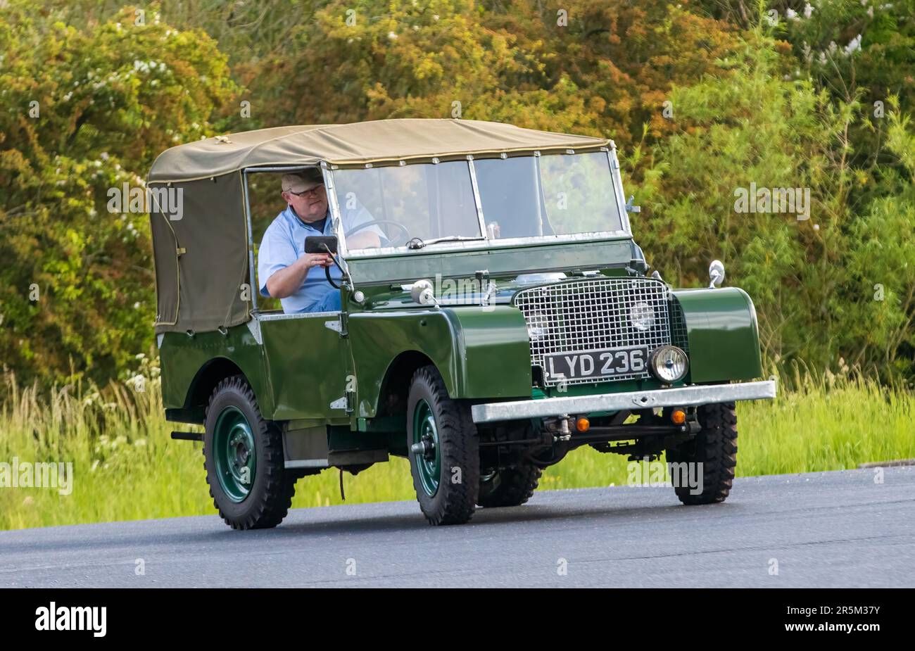 Stony Stratford,UK - June 4th 2023: 1950 green LAND ROVER SERIES 1 classic car travelling on an English country road. Stock Photo