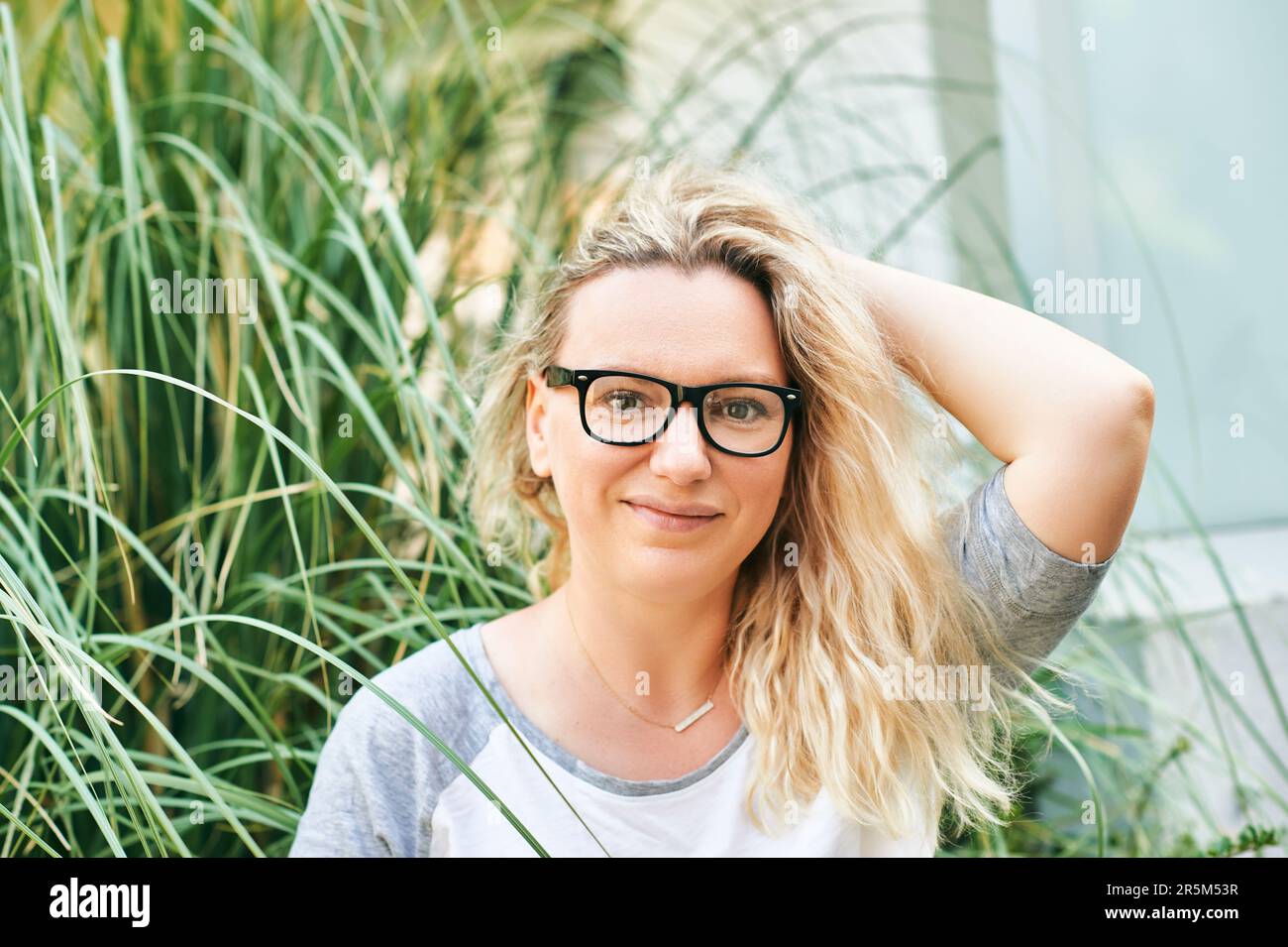 Close up portrait of middle age woman posing outside, wearing eyeglasses Stock Photo
