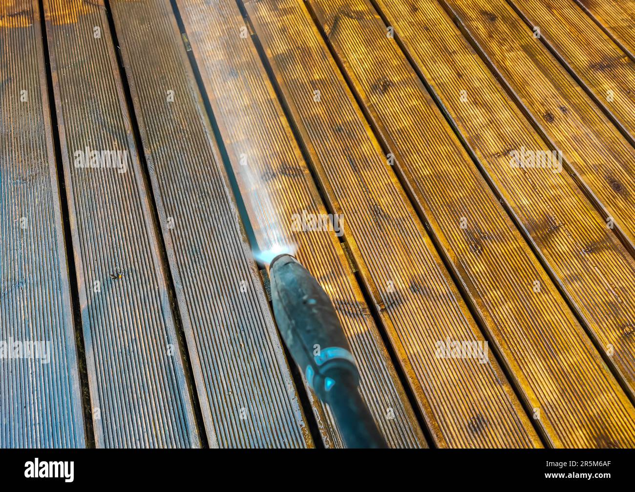 Cleaning wooden terrace decking before oiling and painting with a high pressure water cleaner