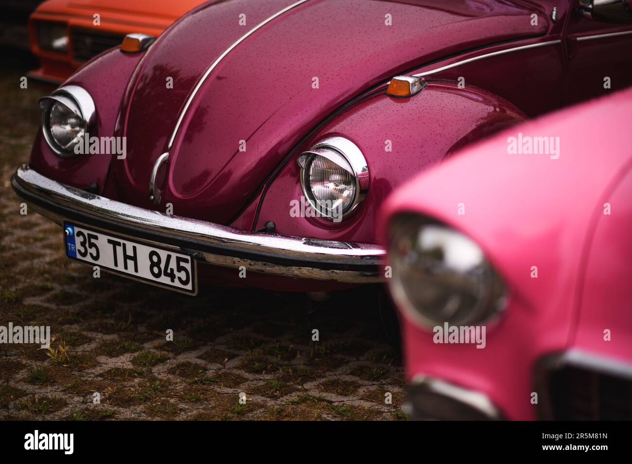 Izmir, Turkey - June 3, 2023: Close-up of the right front headlights of a pinkish-purple 1972 Volkswagen Beetle at the IZKOD Classic Car Meet in Buca Stock Photo