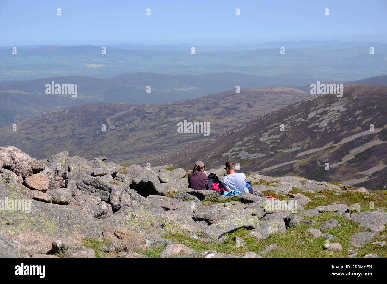 Hikers sitting on top of summit munro Mount Keen, Angus Glens, Scotland Stock Photo