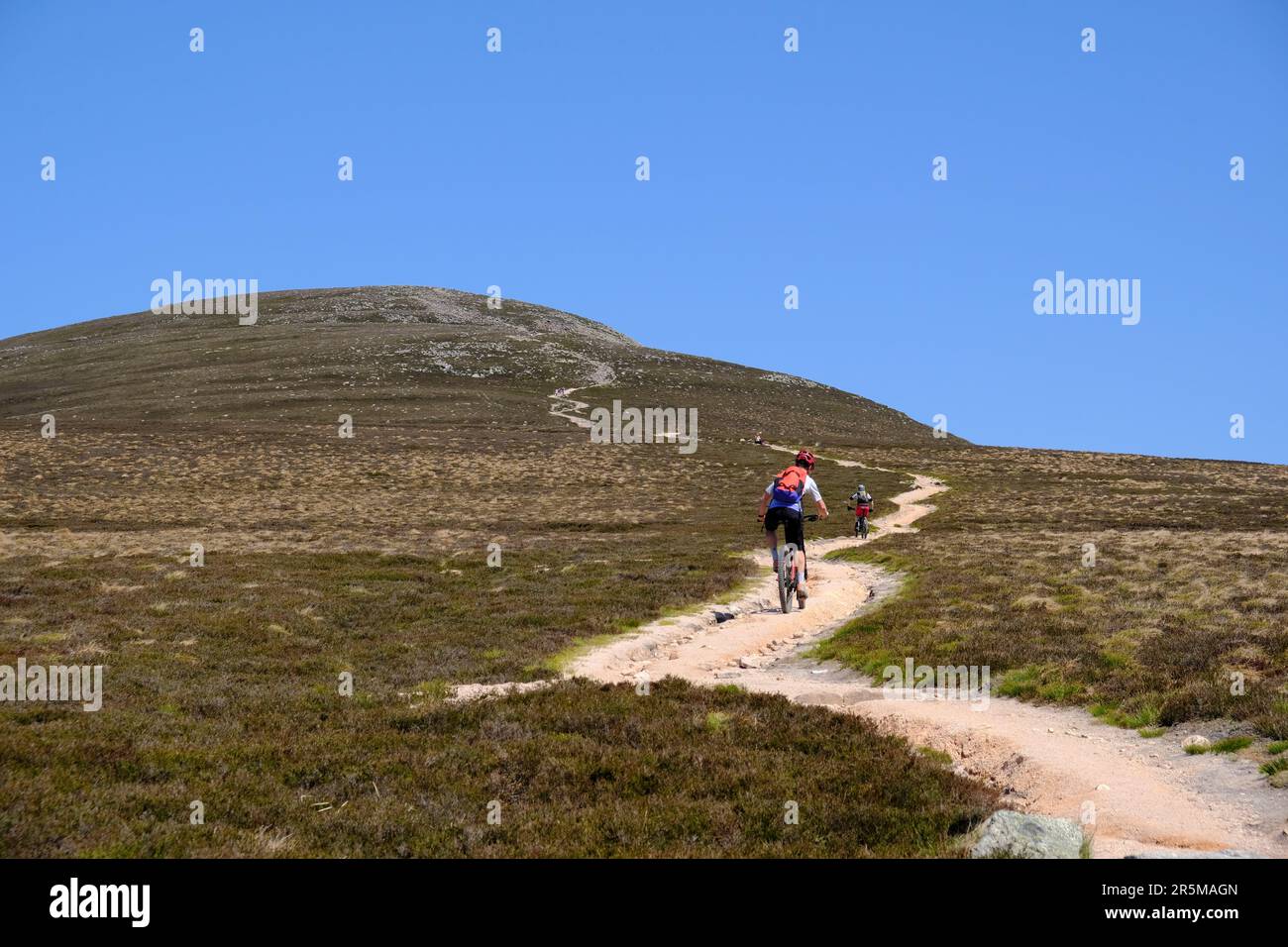 Mountain biking up the track to the summit of munro Mount Keen, Angus Glens, Scotland Stock Photo