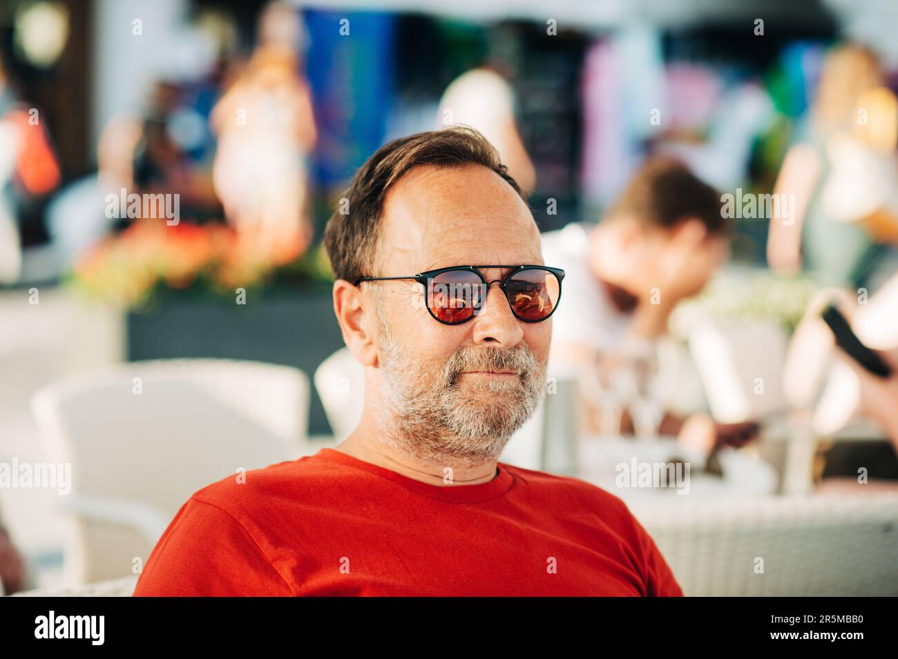 Outdoor portrait of 50 year old man wearing red tshirt and sunglasses