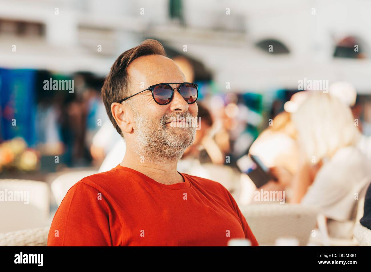 Outdoor portrait of 50 year old man wearing red tshirt and sunglasses