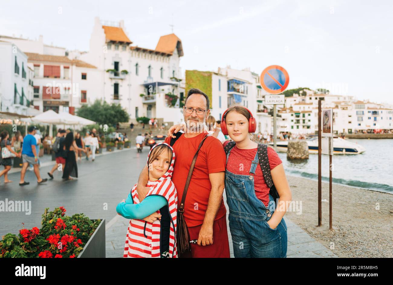Outdoor portrait of happy father with young kids, family spending time together by the sea Stock Photo