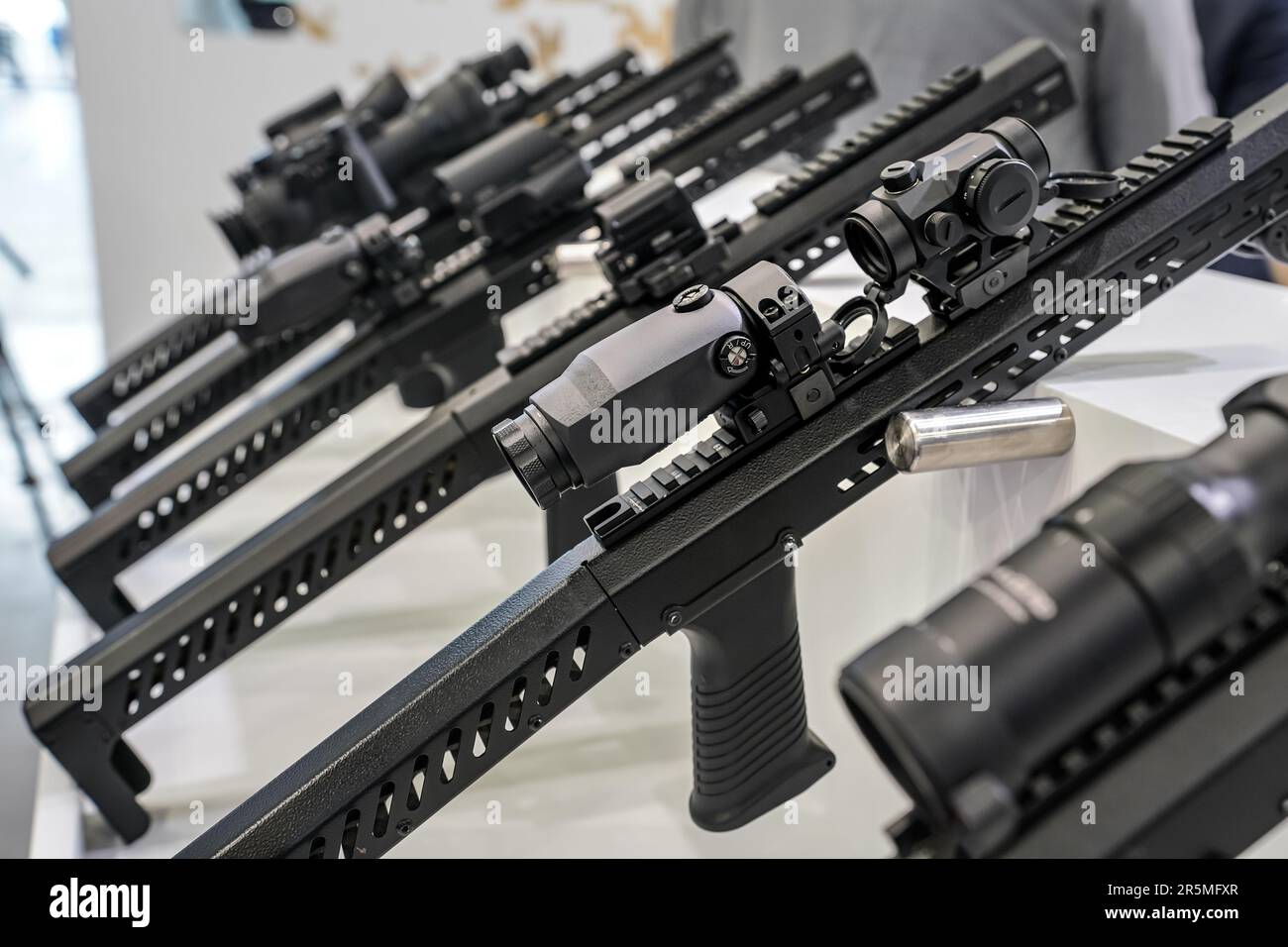 Black shooting scope optics mounted on metal bar displayed at weapons