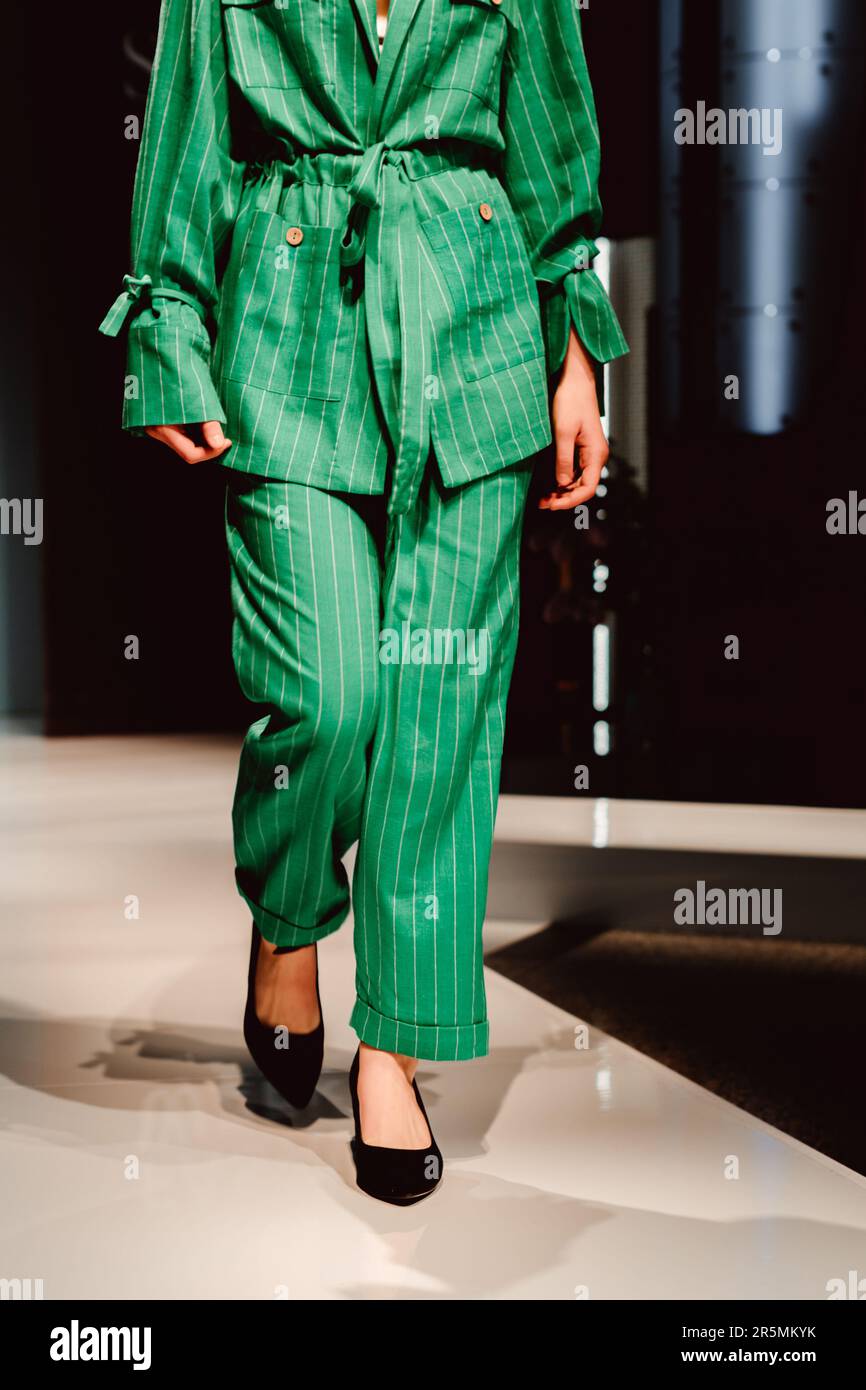 Fashion details of stylish green outfit. Classy jacket, pants, black shoes. Fancy cloth concept Stock Photo