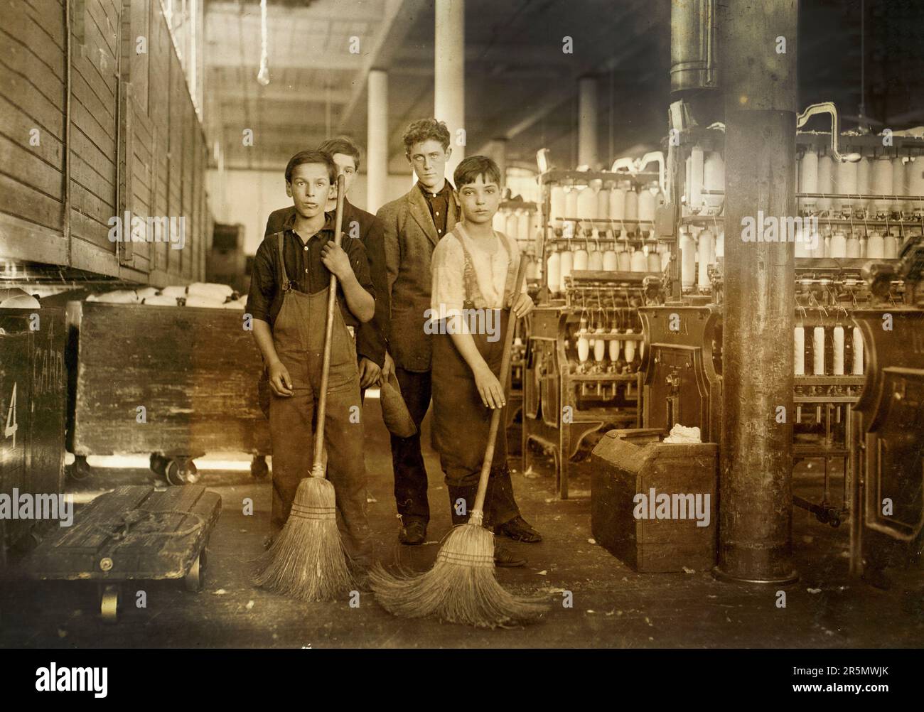 Young sweepers in spinning room of textile mill, New Bedford