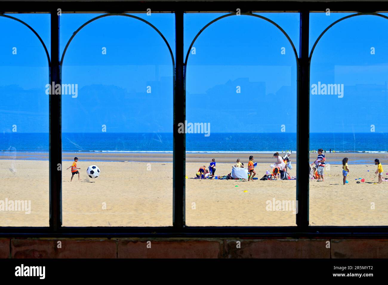 South Shields beach covered walkway boardwalk looking onto the  sandy beach with picnics and footballing families Stock Photo