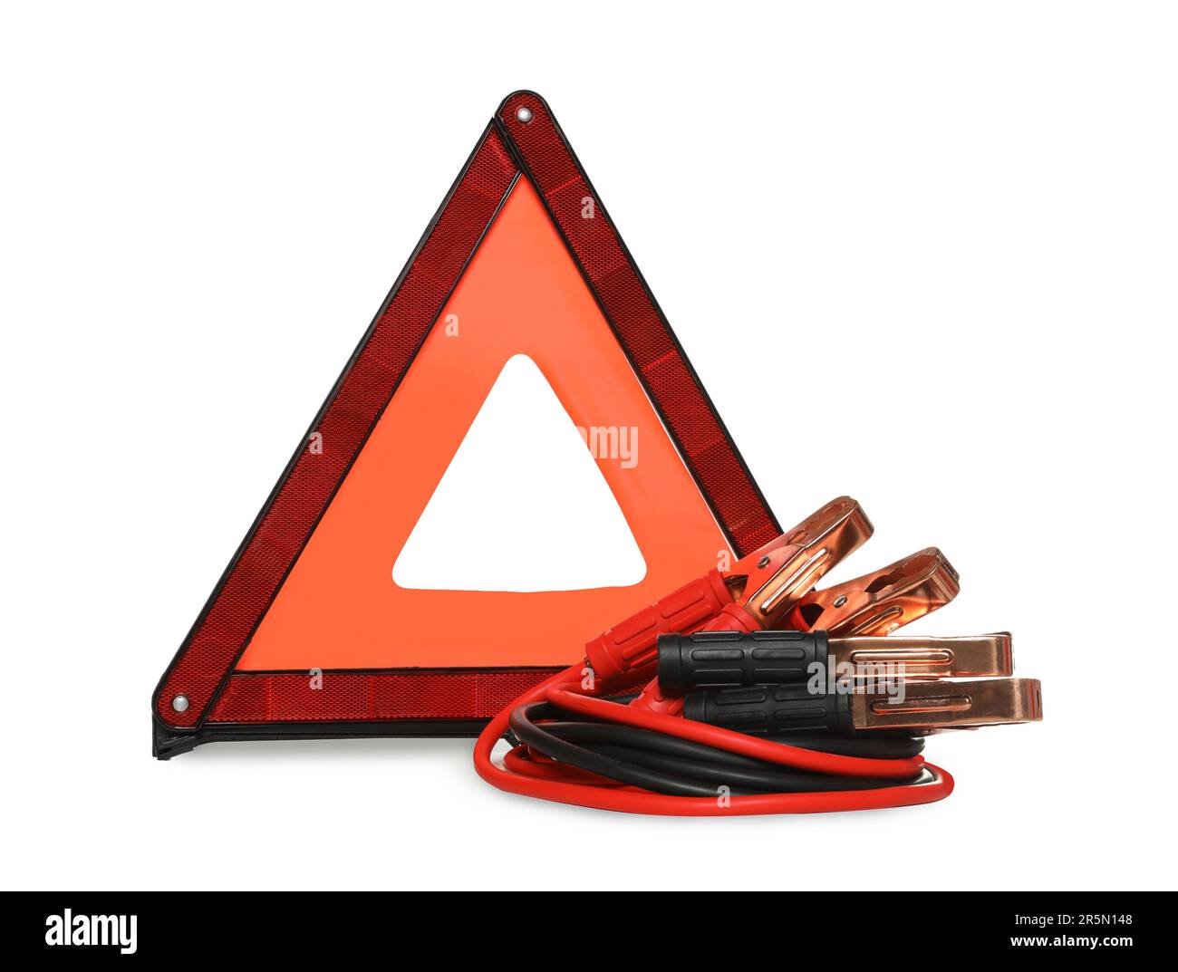 Emergency warning triangle and battery jumper cables on white