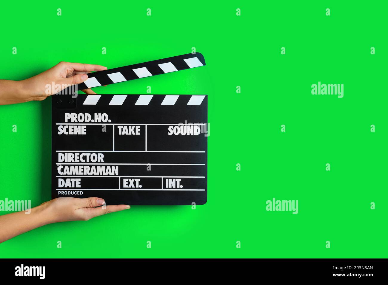 Second assistant camera holding clapper board against chroma key ...