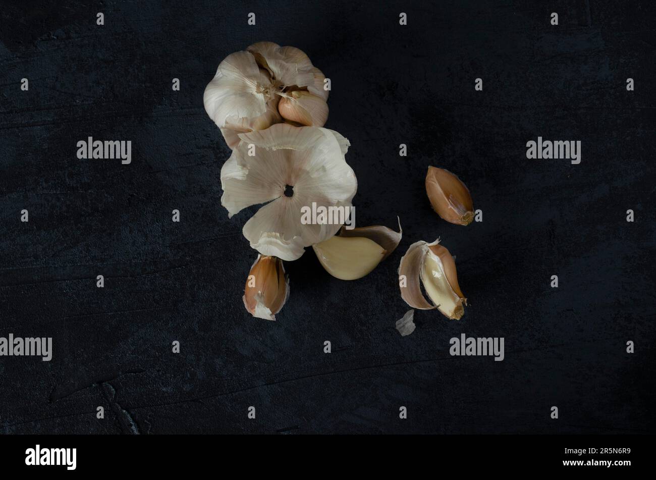 The garlic, garlic cloves and skin on the dark background Stock Photo ...