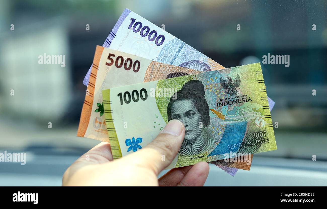 Indonesian man hand holding rupiah money. Indonesian currency. cash in hand concept and close up view Stock Photo