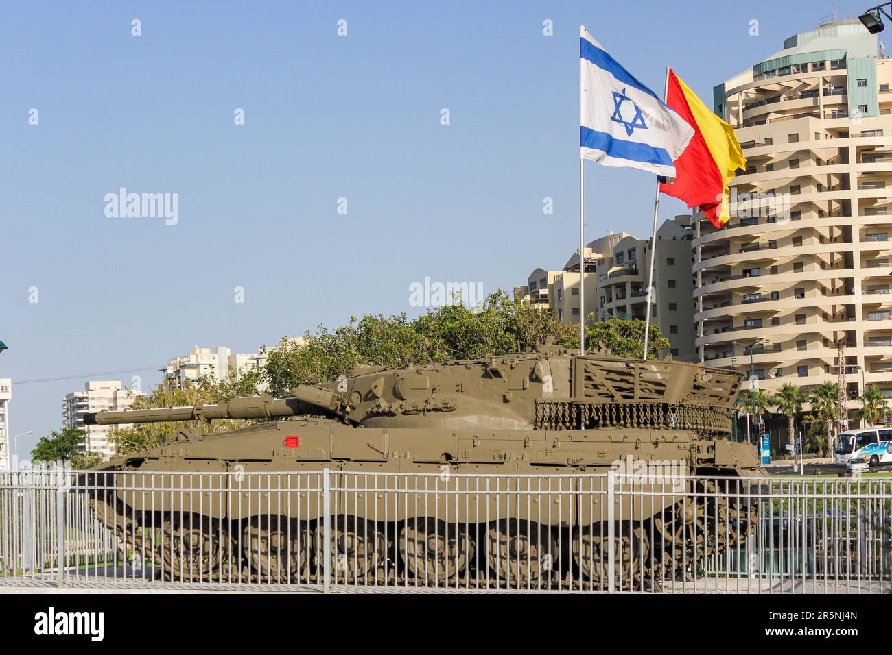 Israeli flags fly above a Merkava tank on display in Netanya, Israel. Stock Photo