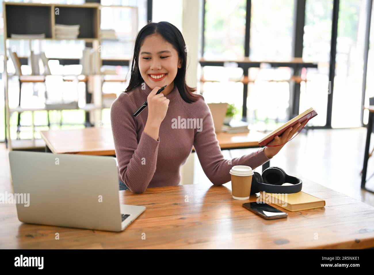 Attractive young Asian female college student working on her school ...