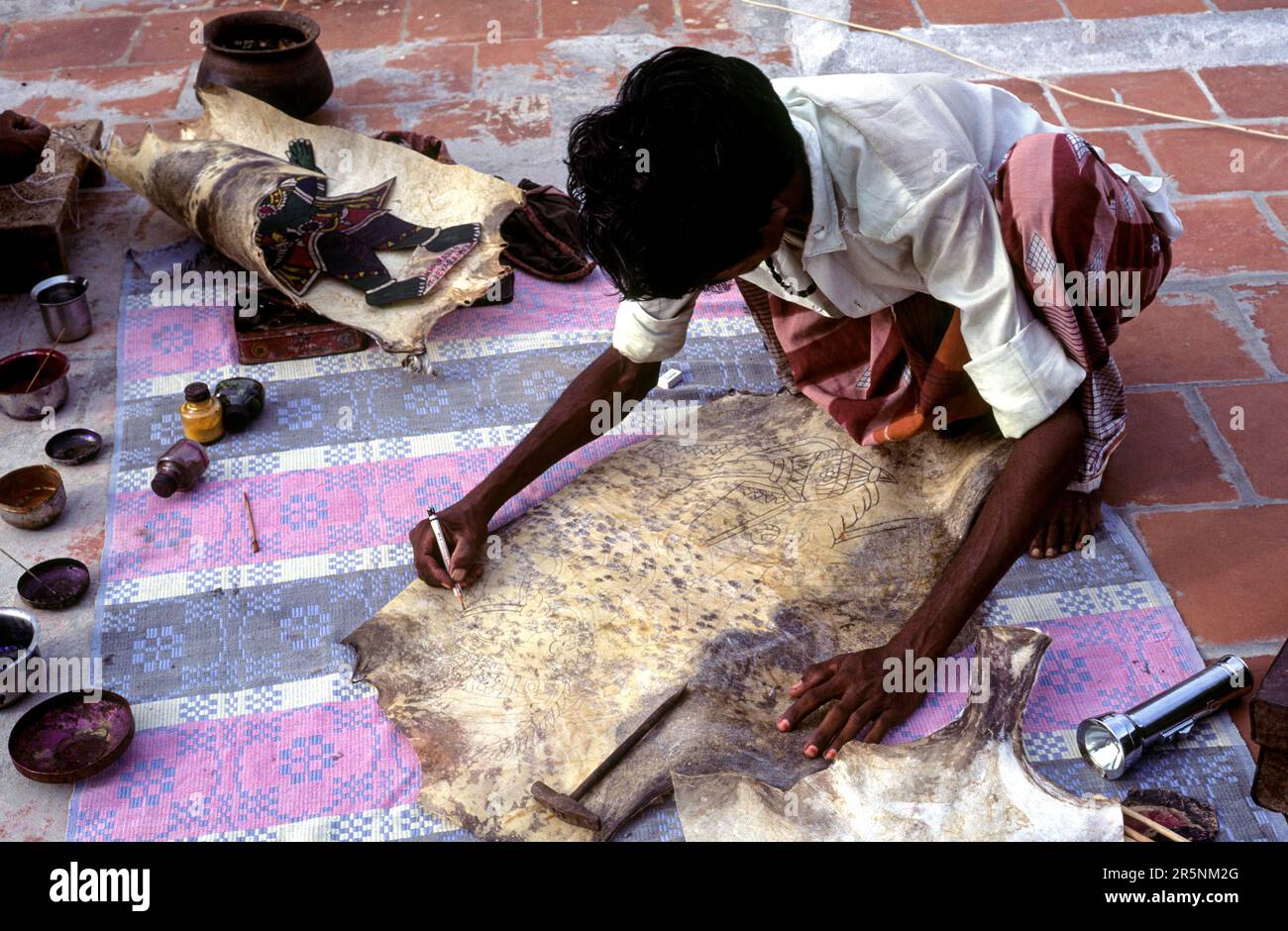 Puppet artist giving shape to the outline leather puppet making at