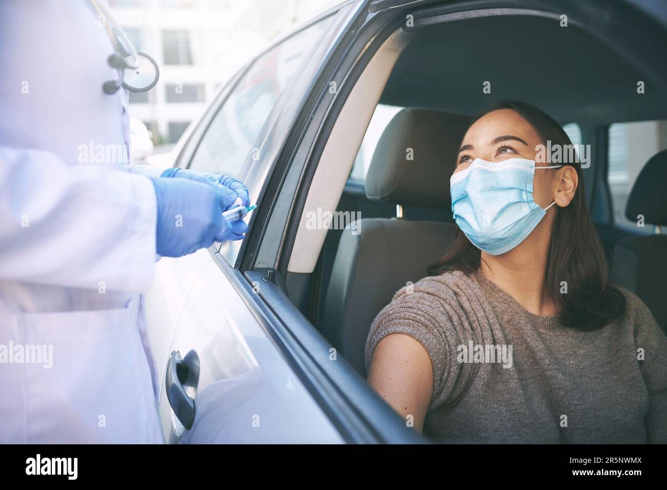 Lets keep our streets clear of corona. a masked young woman receiving ...