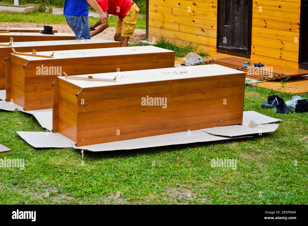 Workers assemble new wooden cabinets furniture in the street. Stock Photo