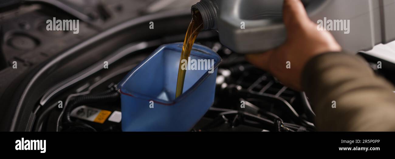 Pouring oil into car engine closeup. Changing oil in engine and gearbox
