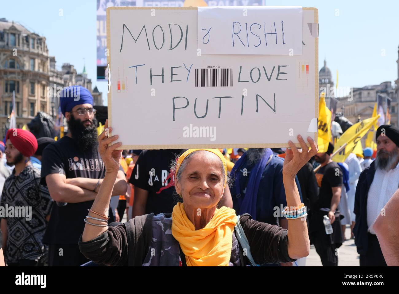 A woman holds up a sign, 'Modi and Rishi. They love Putin' at the anniversary for the Golden Temple massacre in London. Stock Photo