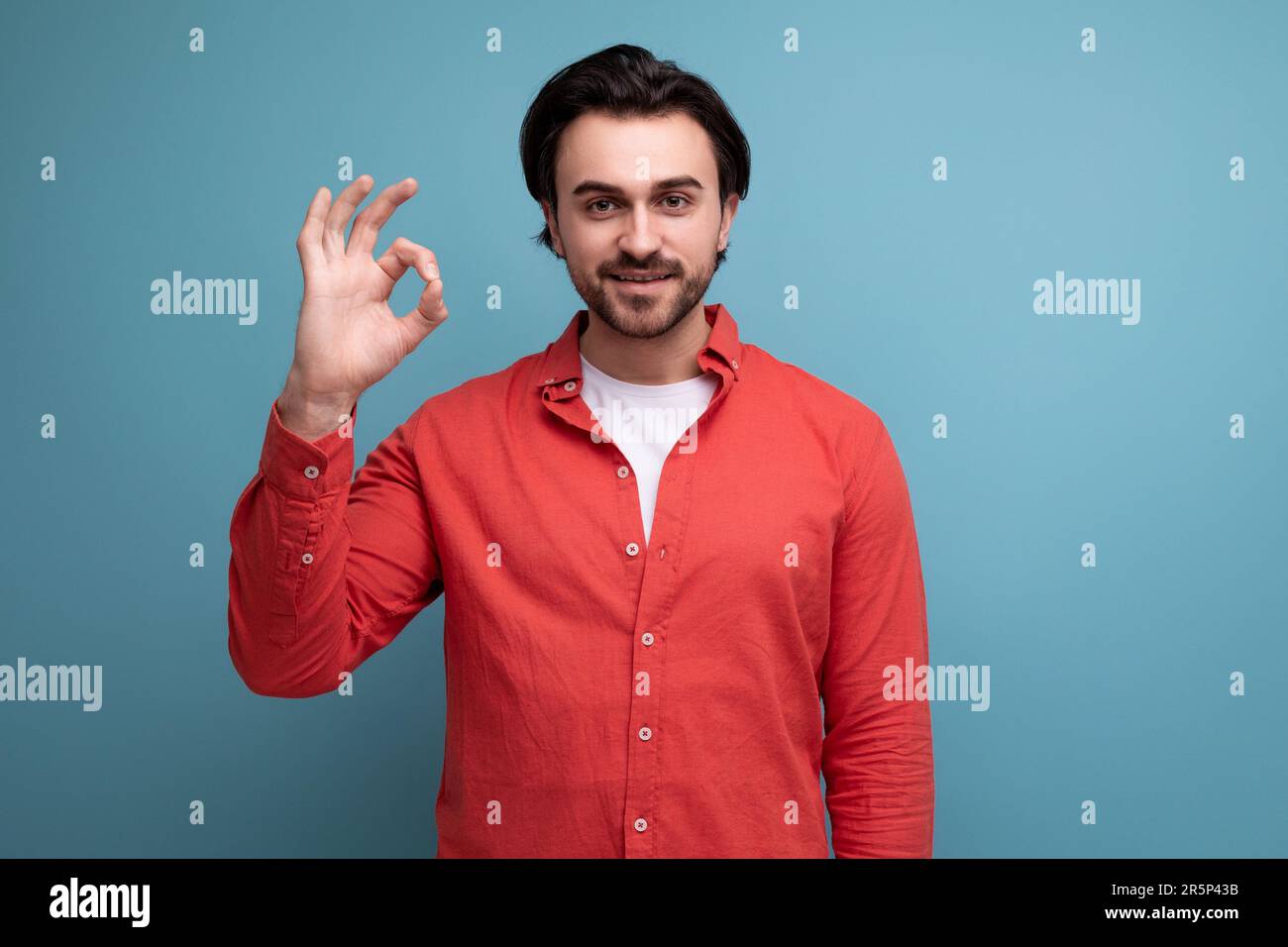 handsome confident dark haired 30s man in red shirt Stock Photo