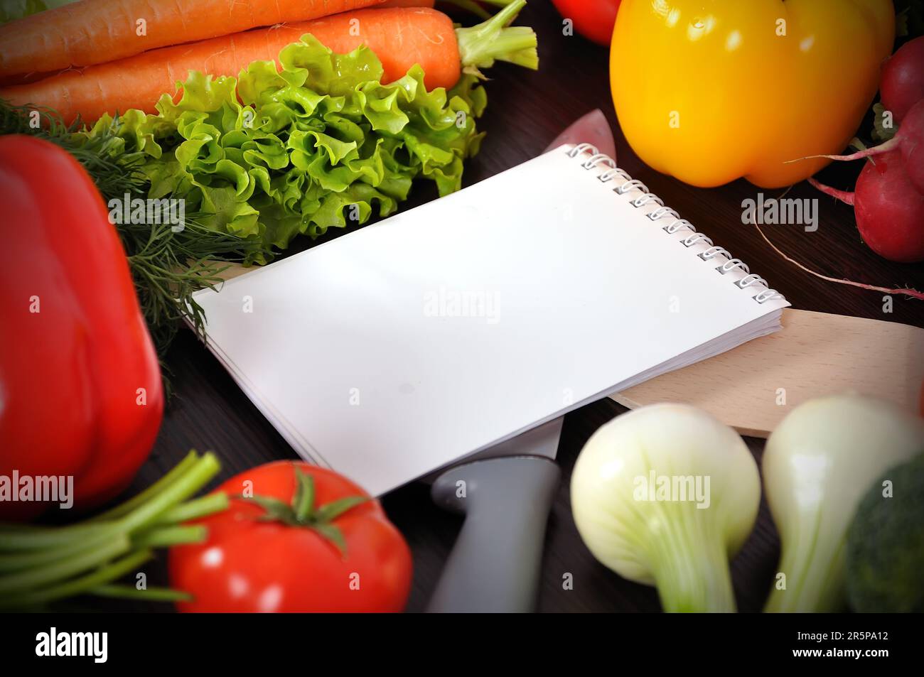 recipe book with vegetables on wooden table Stock Photo