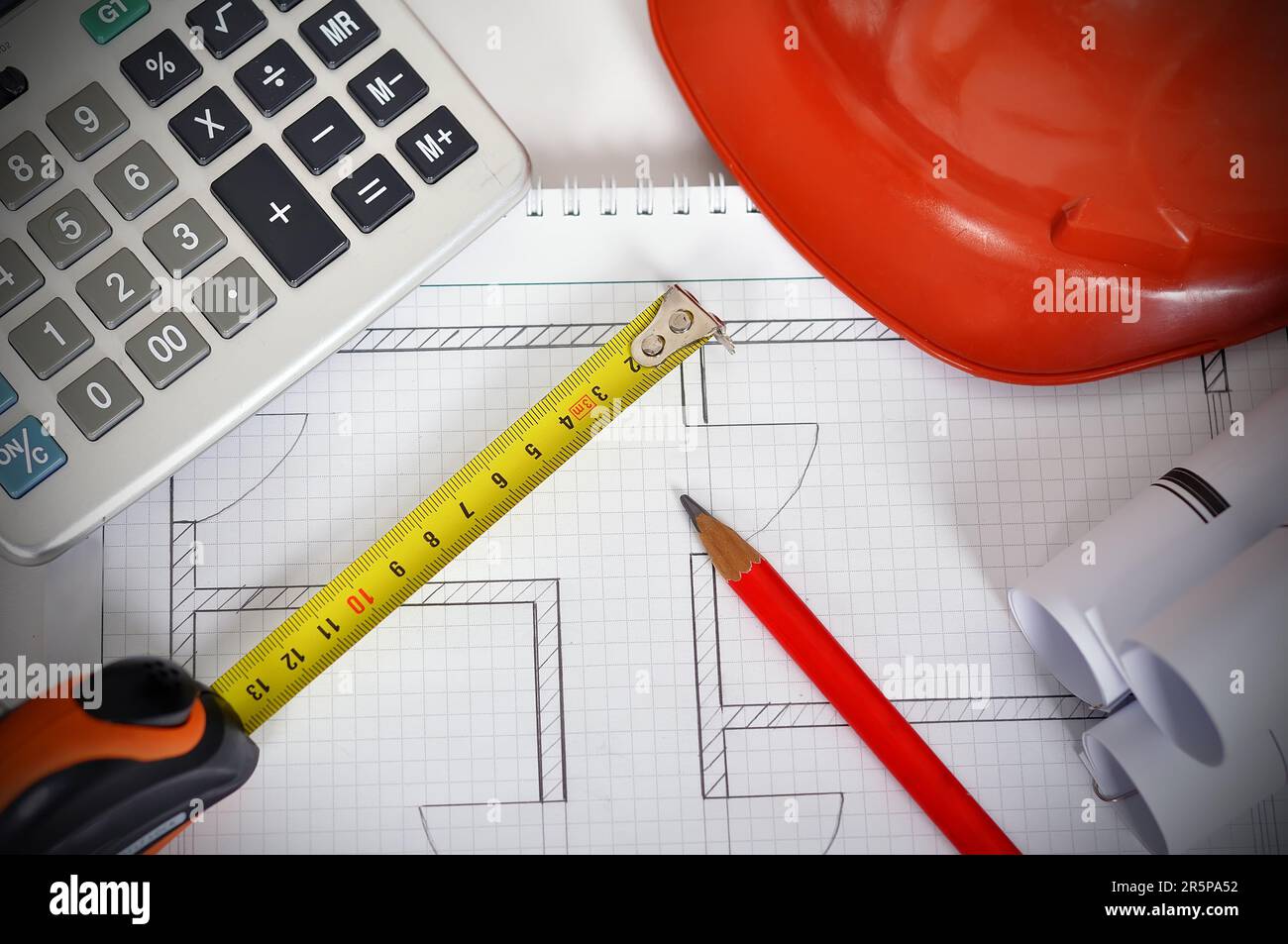 Construction drawings, tape line, calculator and helmet. Desk Engineer