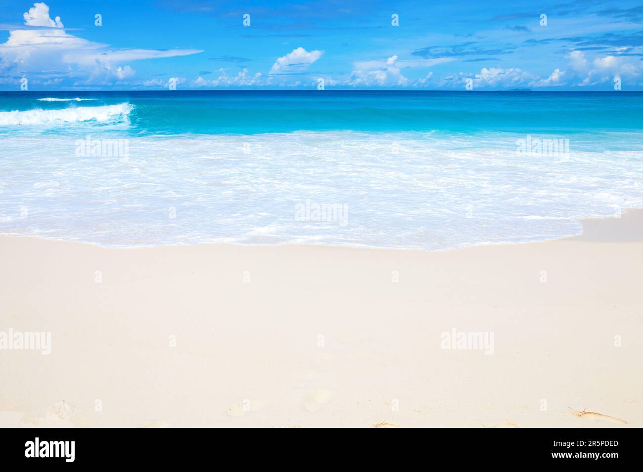 Seascape with white sand on the beach and ocean's turquoise water. Idyllic tropical beach scene. Seychelles. Stock Photo