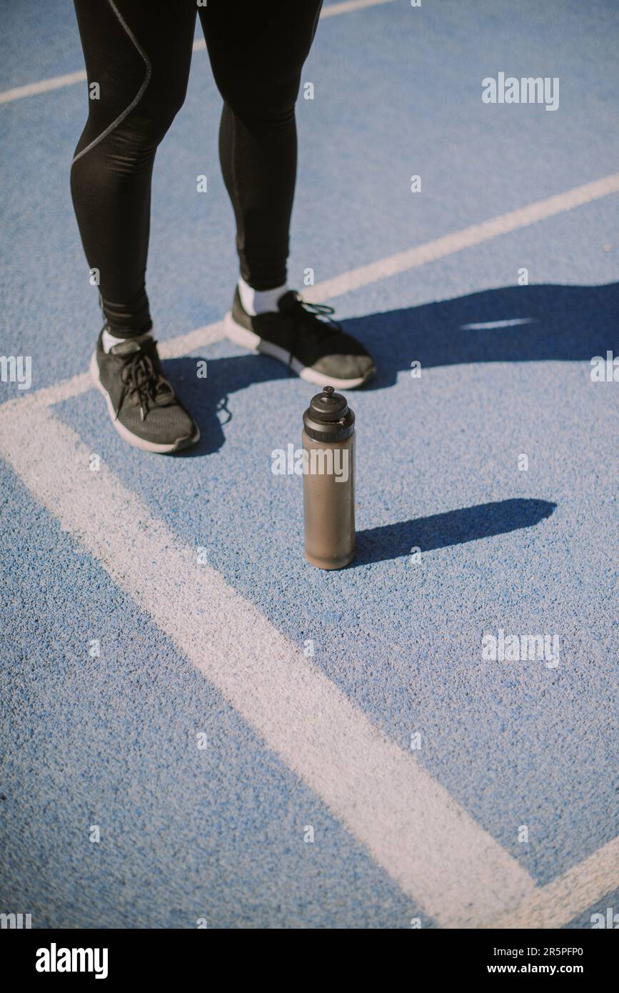 Male sportsperson standing with bottle of water in front of him Stock ...