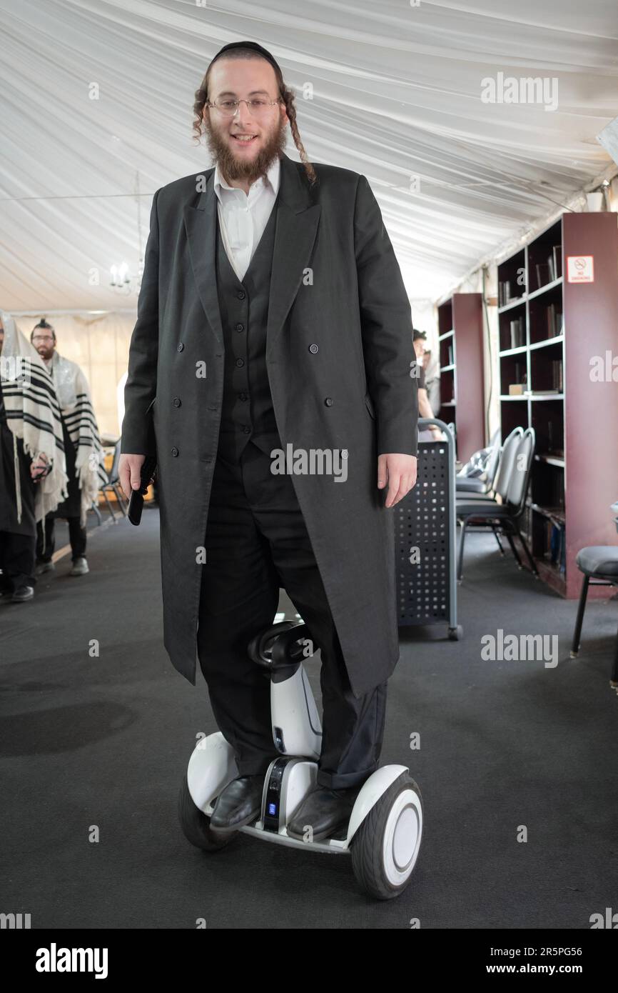 An orthodox Jewish man on a hoverboard inside a synagogue in Monsey
