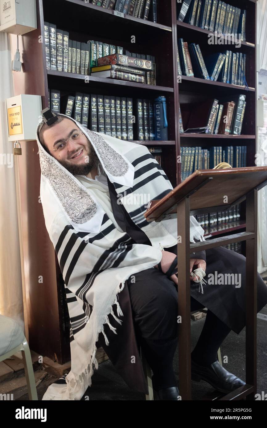 An orthodox Jewish man strikes a playful pose in a synagogue in Monsey
