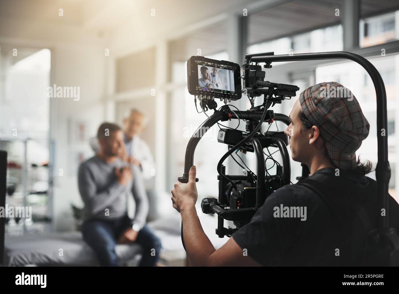 Getting the right shots. Behind the scenes shot of a camera operator shooting a scene with a state of the art camera inside of a studio during the day Stock Photo