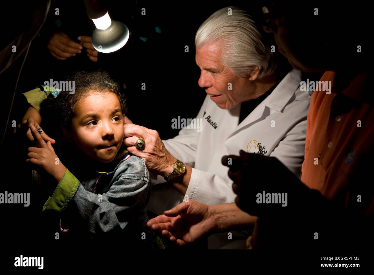 SHF's founder and CEO fits a 4 year old girl, from Cairo with hearing aids. Stock Photo