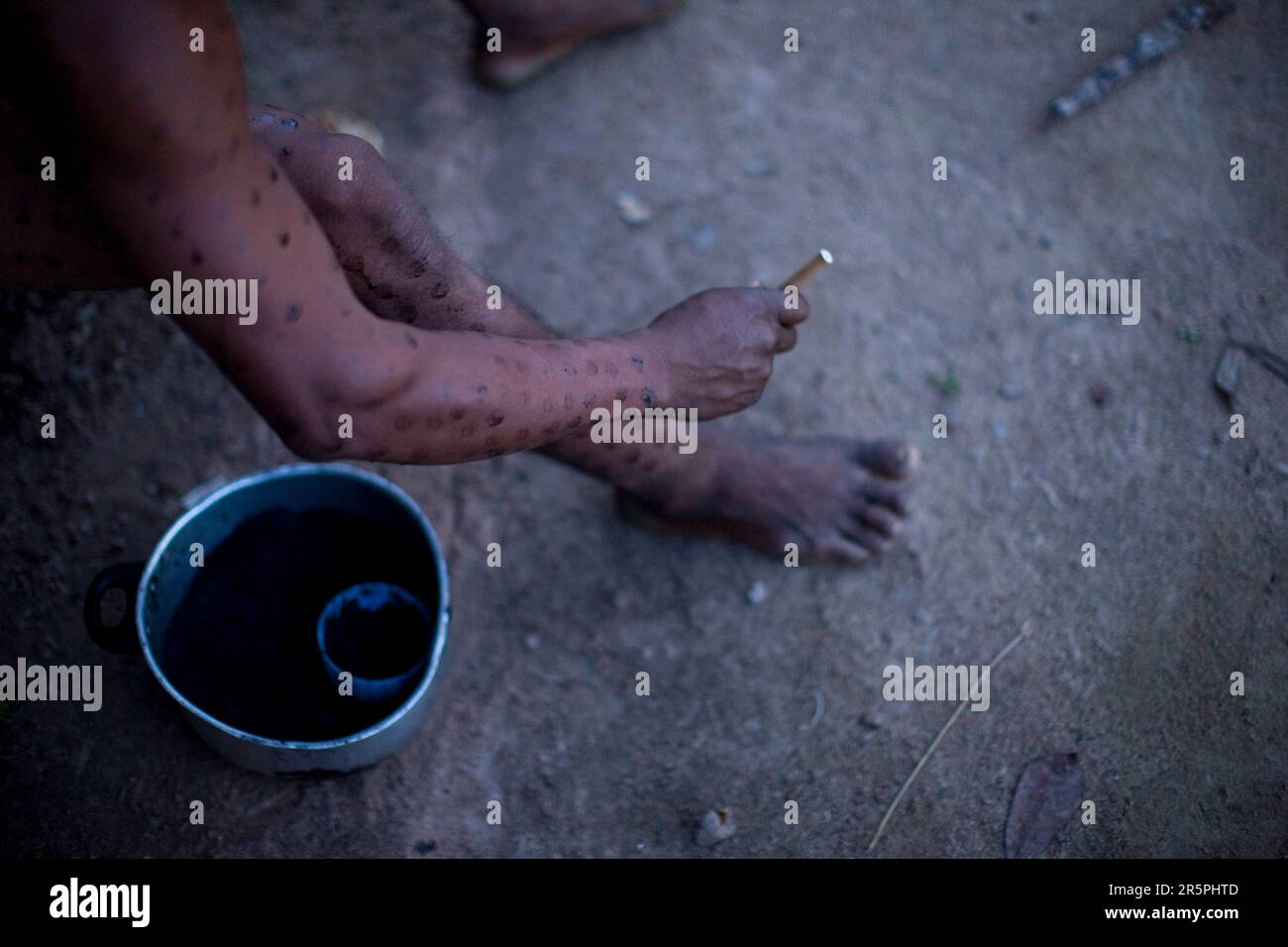 The current chief of an indiginous tribe paints his body with dried genipa in preparation for a festival, Sao Luis Indian Post, Amazon Basin, Brazil. Stock Photo